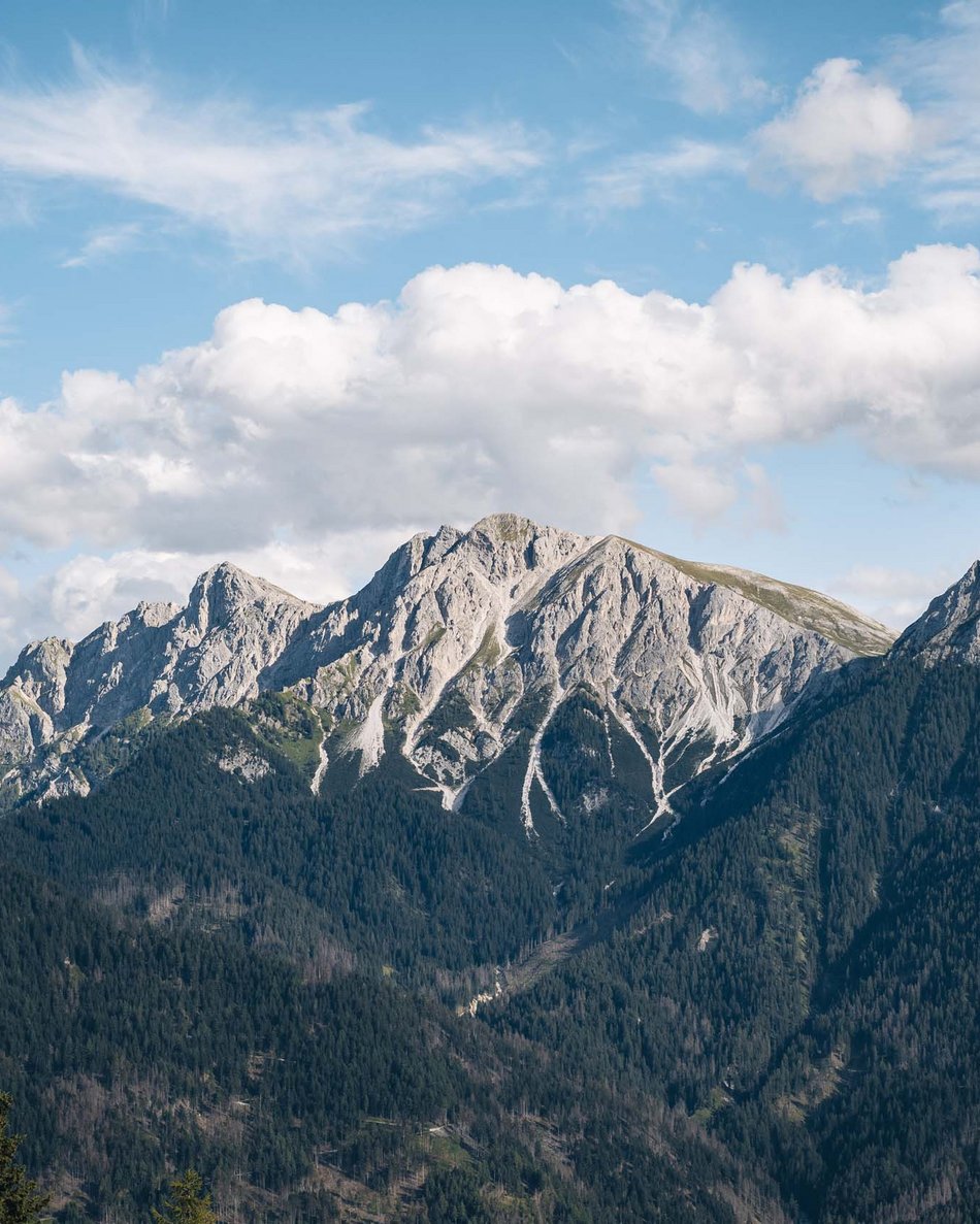 Eventi aziendali, congressi, team building e molto altro Mountain range with rocky peaks and forest under cloudy sky