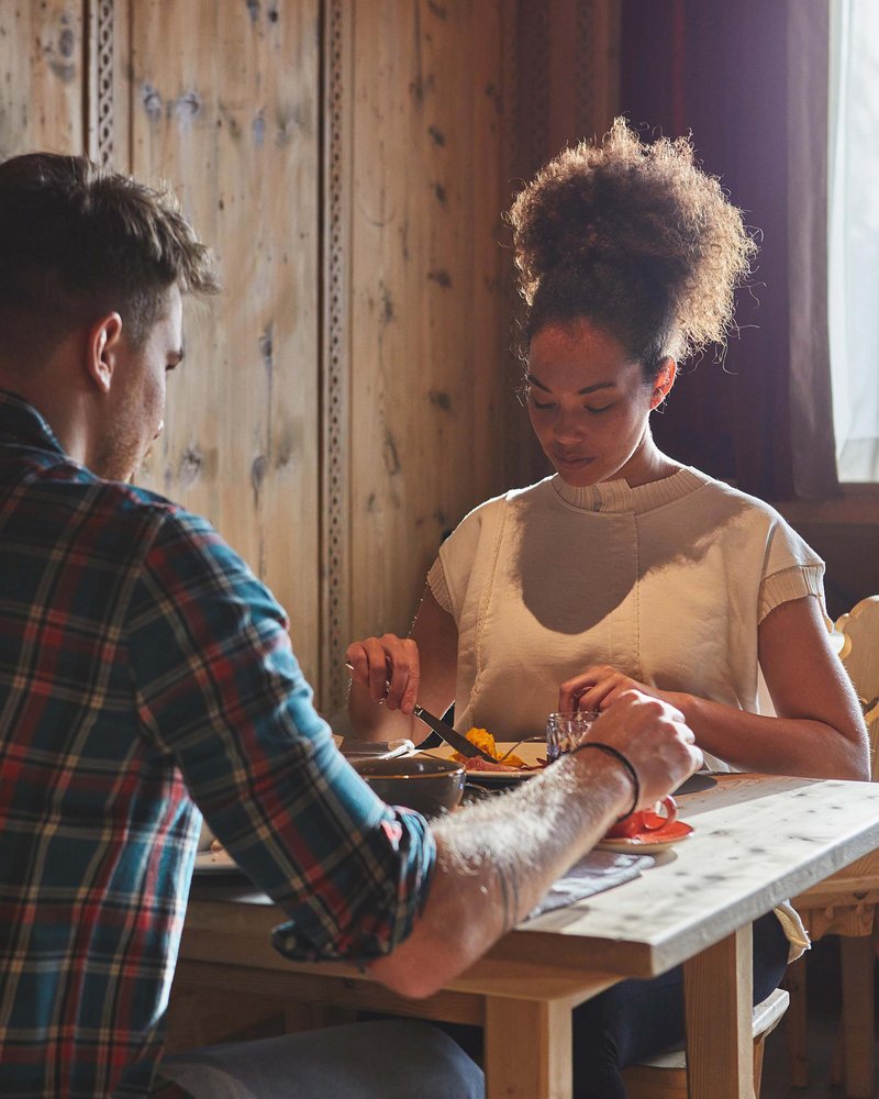 Il tuo hotel in Val Pusteria: Olangerhof Coppia che cena insieme in una stanza rustica illuminata dalla luce naturale
