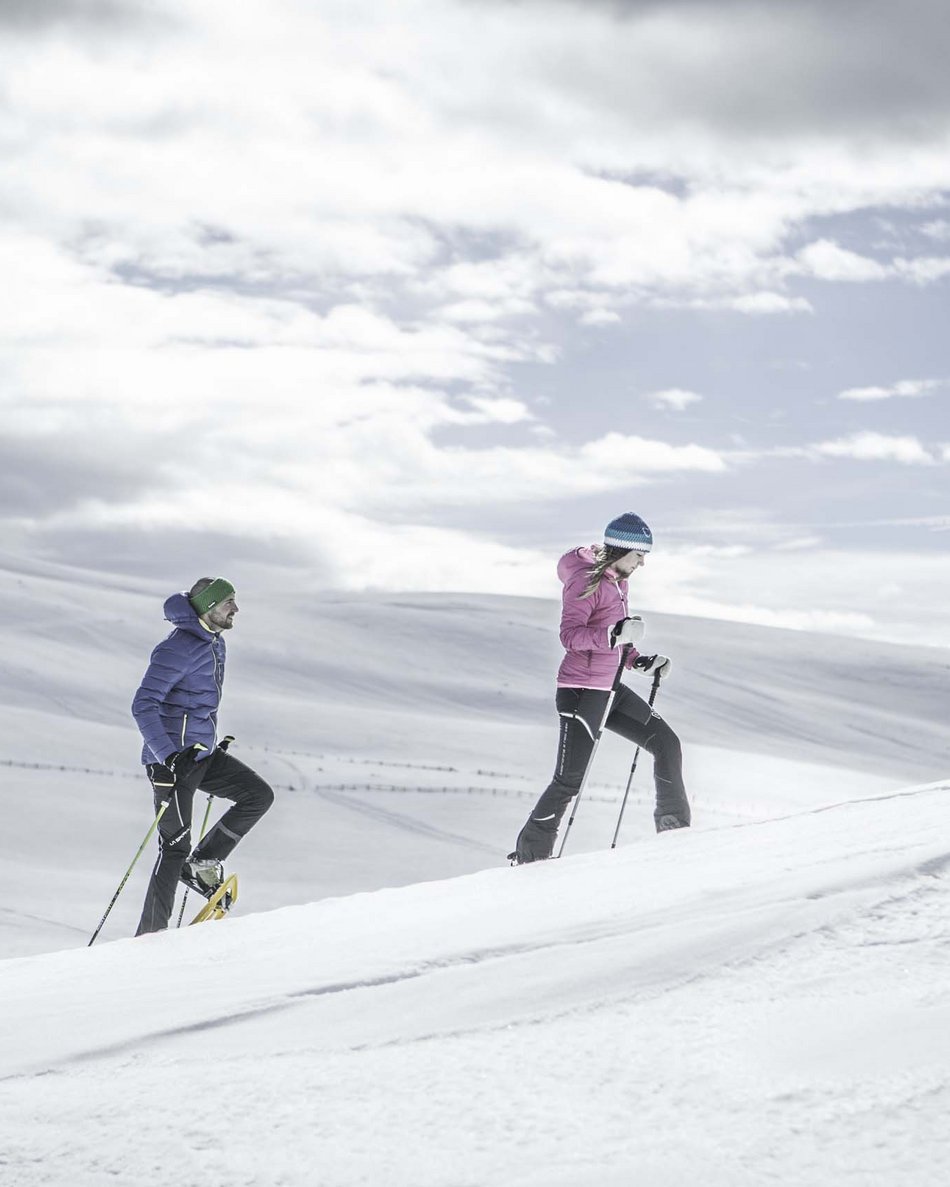 Il tuo hotel in Val Pusteria: Olangerhof Tre persone fanno racchette da neve in un paesaggio innevato