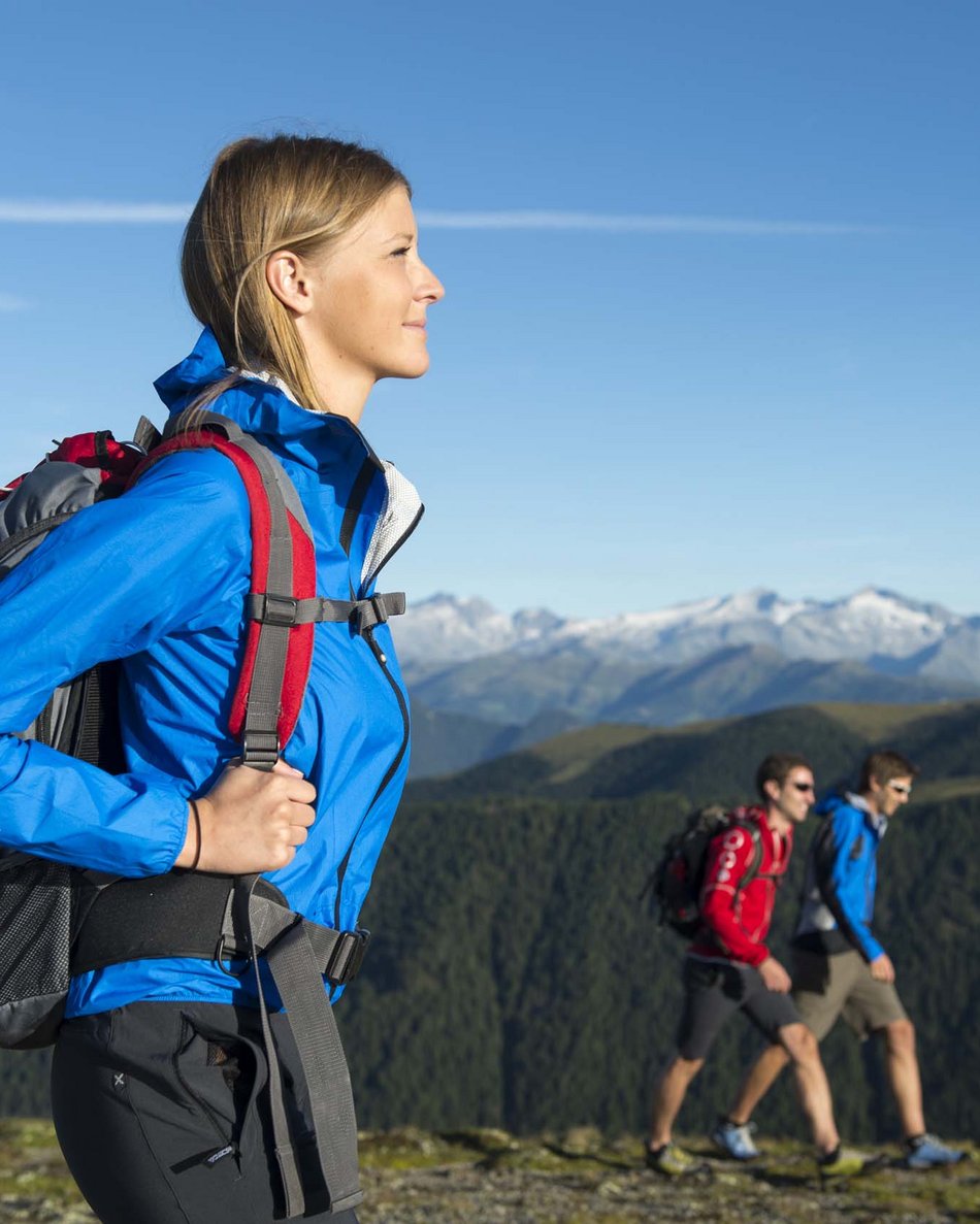 Il tuo hotel in Val Pusteria: Olangerhof Donna che fa trekking con zaino su sentiero di montagna soleggiato