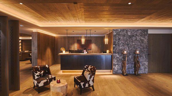 In Olang: a hotel with “Oh”, “Aah”, and “Wow” Cozy reception area with wooden furniture and two chairs with a log table